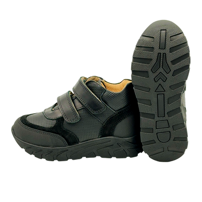 A side view of plain black orthopedic sneakers for kids with arch and enhanced ankle support. These sneakers feature a sleek and stylish design, making them suitable for school dress codes. The enhanced ankle support and arch support provide optimal stability and comfort for growing feet. The side view showcases the sneakers' construction and supportive features, ensuring the well-being of active kids throughout the day.