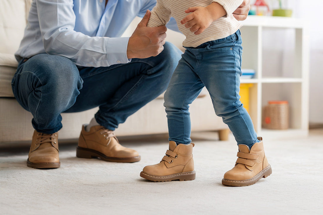 Child wearing supportive orthopaedic shoes, standing with a parent nearby in a bright family setting. Perfect featured image for an article about flat feet in children and healthy foot development.