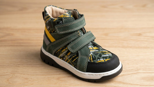 Side view of a leather high-top children's orthopaedic shoe highlighting the plush padded collar and secure top ankle strap.