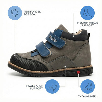 Children’s orthopedic shoe in gray with blue straps labeled ‘Ortho,’ showing reinforced toe box, arch support, and Thomas heel.