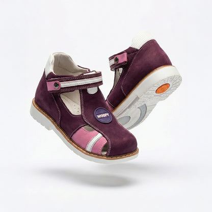 Girls’ orthopedic shoes in dark purple with cutout sides, Velcro fastening, arch support, and Thomas heels, featuring ‘WOOPY’ logo patch.