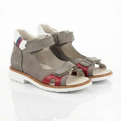 Supportive boys’ orthopedic sandals with Velcro straps, arch and ankle support, Thomas heels, and padded striped heel section by Woopy.