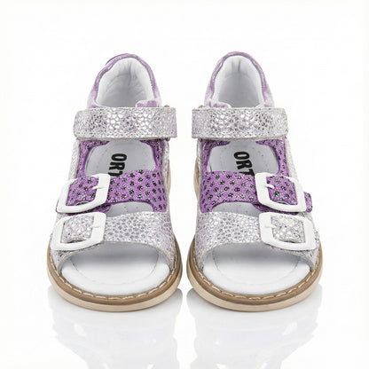 Supportive girls’ orthopedic sandals with glitter floral design, white buckles, arch support, and Thomas heels by Ortho Shoes.