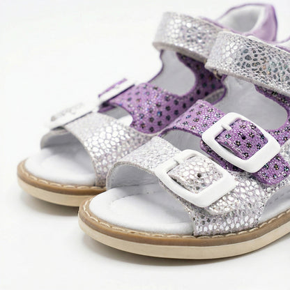 Supportive girls’ orthopedic sandals with glitter floral design, white buckles, arch support, and Thomas heels.