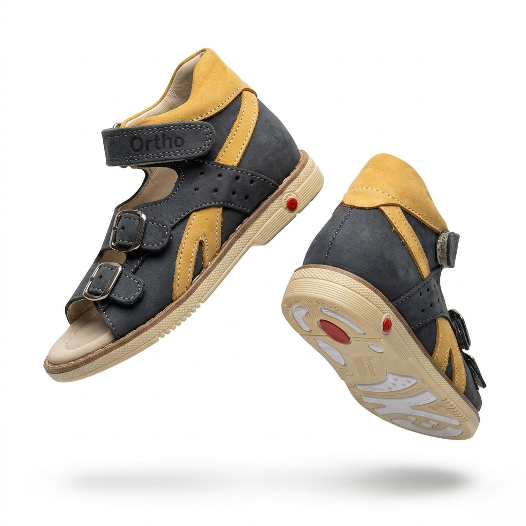 Children’s dark grey orthopedic sandals with yellow accents, multi‑strap, arch and ankle support, and rugged sole with Thomas heels by Ortho Shoes.