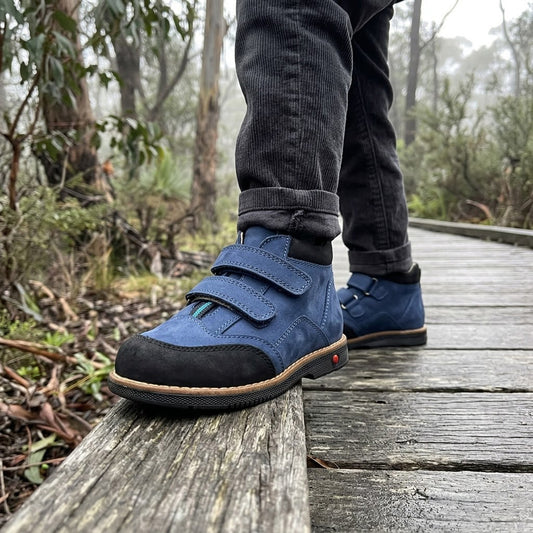 Blue and black nubuck leather kids orthopaedic mid-top boots with arch support and double Velcro straps.