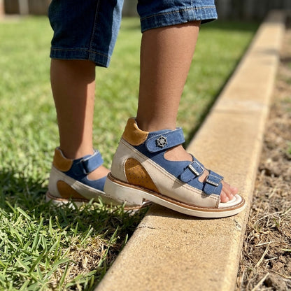 Kids orthopaedic sandals in matte blue and beige leather with structured arch support and three straps.
