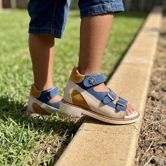 Kids orthopaedic sandals in matte blue and beige leather with structured arch support and three straps.