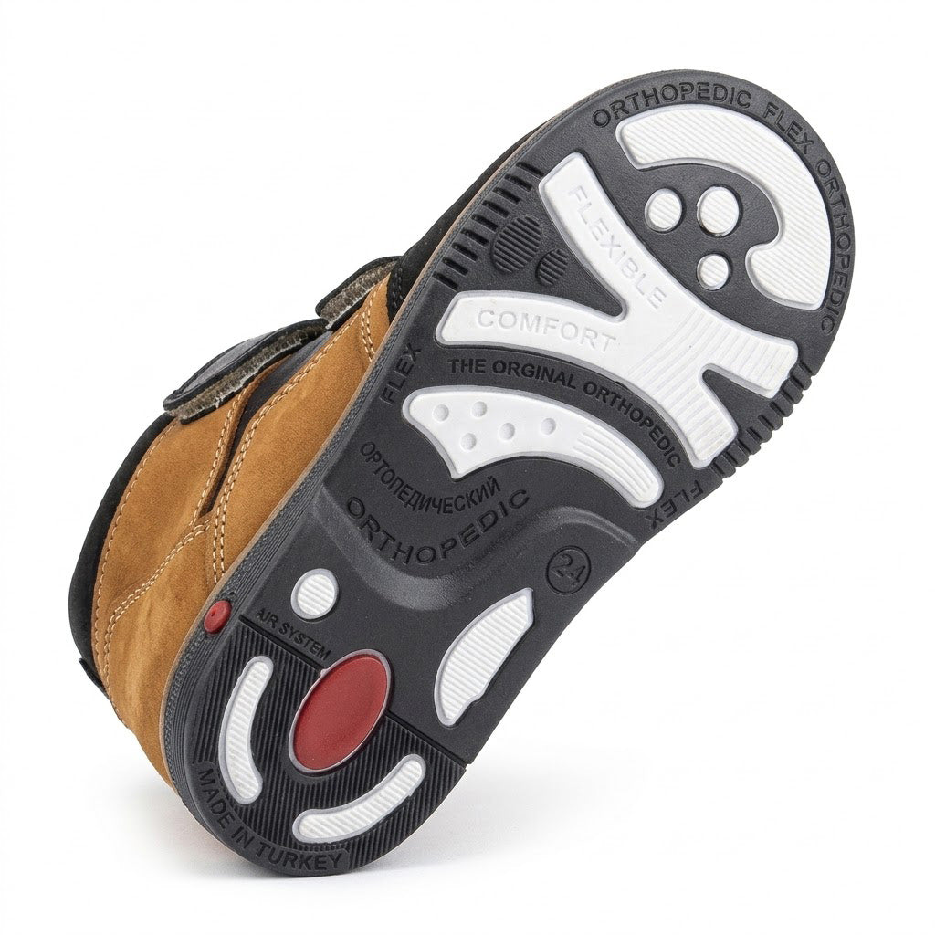 Orthopaedic boot outsole showing structured grip tread, impact-cushioning zones, and medial Thomas heel extension.