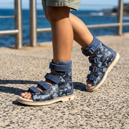 Kids high-top orthopaedic open-toe sandals in navy camo leather with ankle support, Velcro straps, and cream sole.
