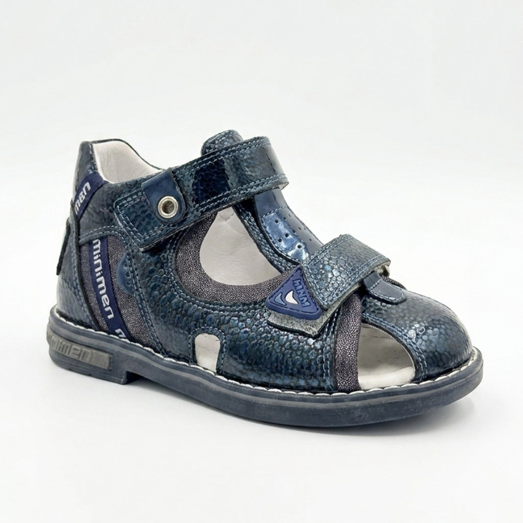 Children’s orthopedic sandal by Minimen in navy, highlighting its arch support, ankle support, and Thomas heel construction in a studio-style image.
