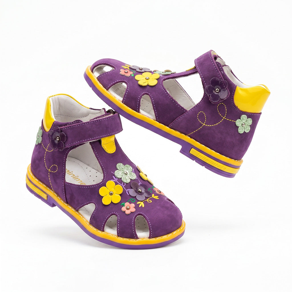 Girls’ purple orthopedic sandals with arch and ankle support, Thomas heels, multicoloured flower appliqués, and a secure Velcro strap by Minimen.