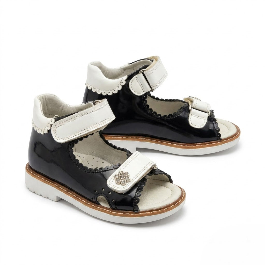 Side view of girls navy leather open-toe sandals showing built-in arch support, sturdy Thomas heel, and white sole.