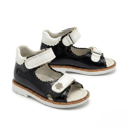 Side view of girls navy leather open-toe sandals showing built-in arch support, sturdy Thomas heel, and white sole.