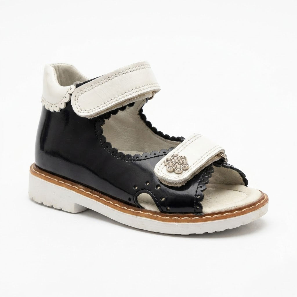 Side view of girls navy leather open-toe sandals showing built-in arch support, sturdy Thomas heel, and white sole.