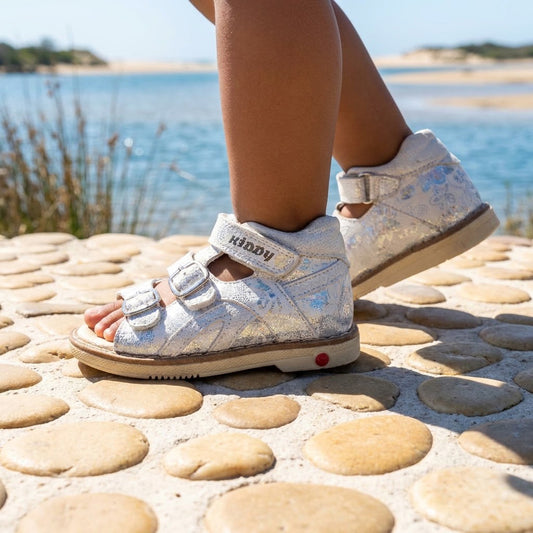 Girls silver orthopaedic mid-top sandals with floral crackle print, adjustable straps, and Thomas heel sole.