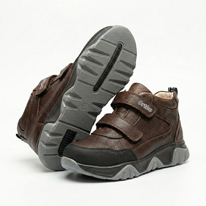 Children’s orthopedic boots in brown with Velcro straps, arch and ankle support, and Ortho Shoes logo.