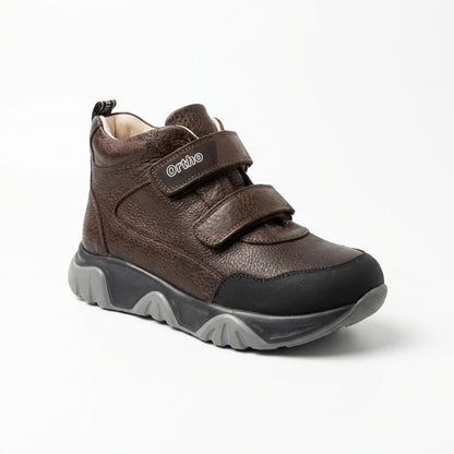Children’s orthopedic boots in brown with Velcro straps, arch and ankle support, and Ortho Shoes logo.