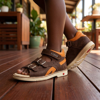 Boys brown nubuck orthopaedic sandals with orange accents, 3 straps, arch and ankle support, and cream sole.
