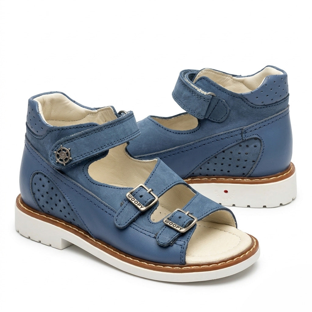 Blue mid-top orthopaedic sandals with a sturdy white sole, Thomas heel, perforated leather, and ship helm charm.