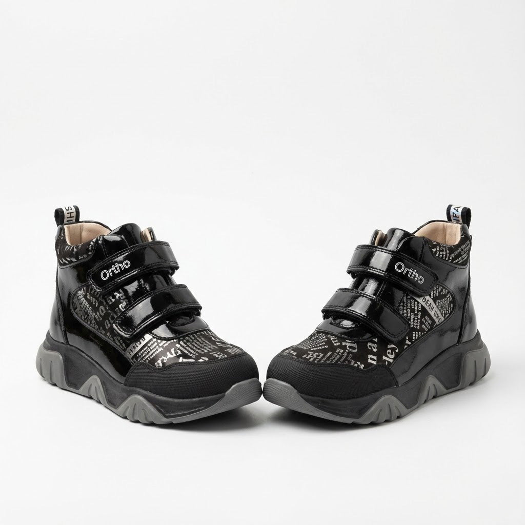 Supportive orthopedic sneakers for kids with dual Velcro closure, printed upper, rugged sole, and Ortho branding.