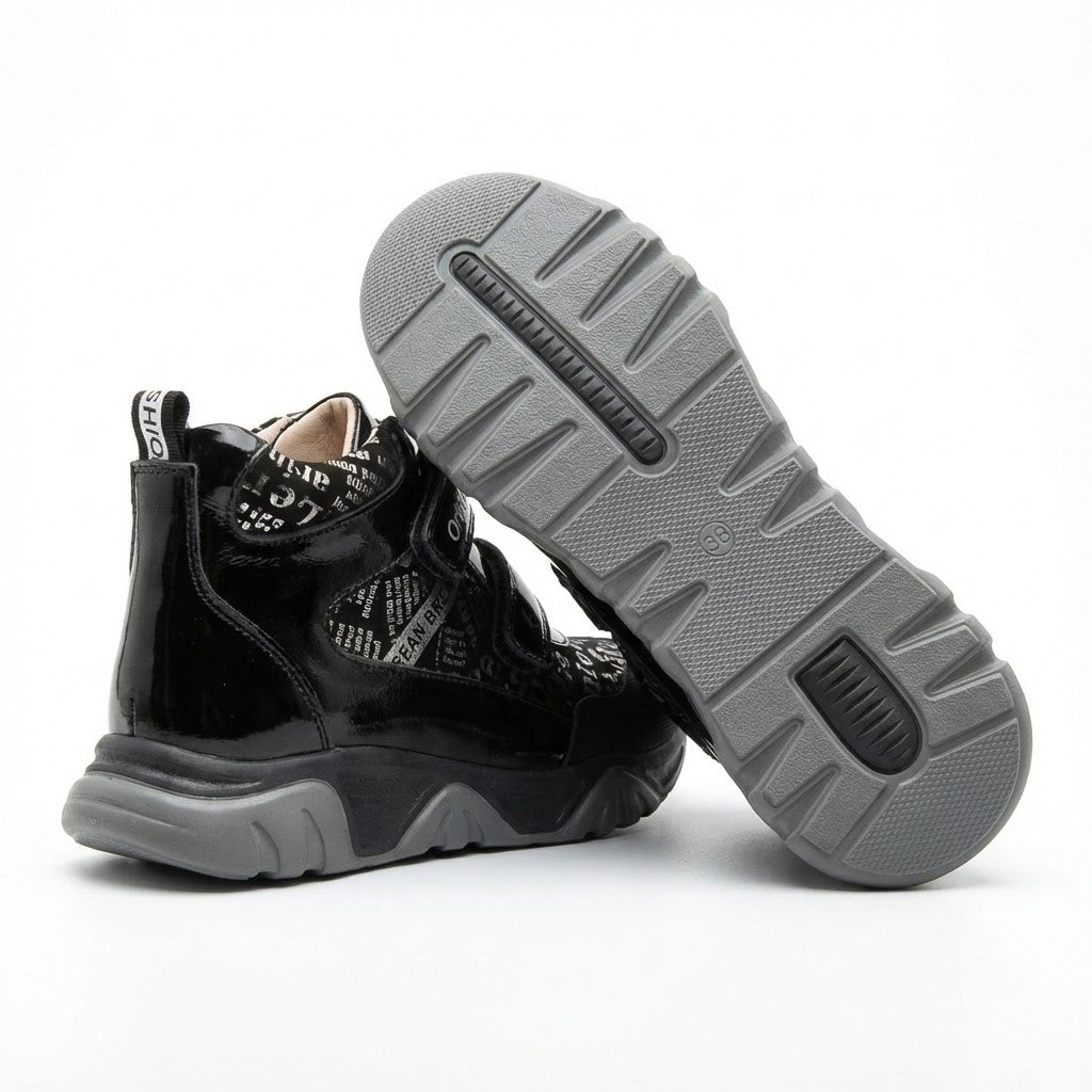 Supportive orthopedic sneakers for kids with dual Velcro closure, printed upper, thick sole, and Ortho branding.