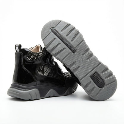 Supportive orthopedic sneakers for kids with dual Velcro closure, printed upper, thick sole, and Ortho branding.