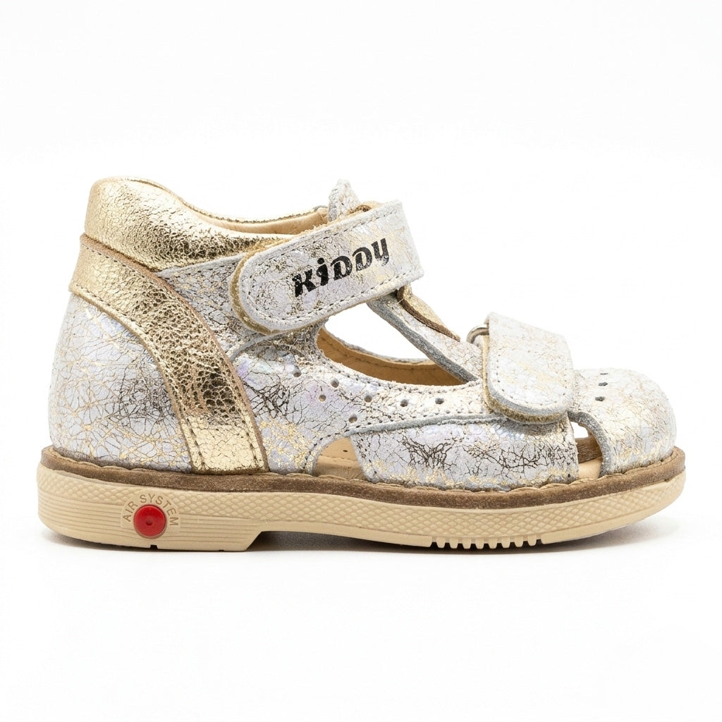 Kids’ silver Kiddy sandal with gold accents, dual Velcro straps, cracked‑texture upper, cushioned arch support, ankle support and Thomas heels.