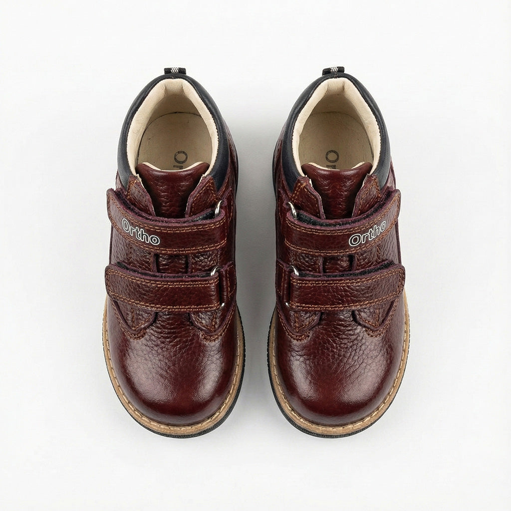 Supportive orthopedic boots for kids in brown with dual Velcro closure, padded lining, Thomas heels and Ortho branding.