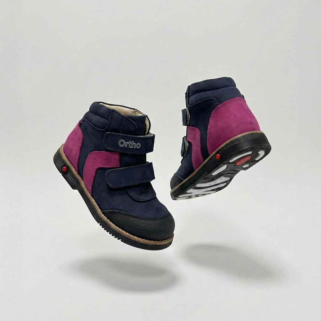Girls’ orthopedic shoe in navy and pink with Velcro straps, arch support, Thomas heel, and Ortho Shoes branding.