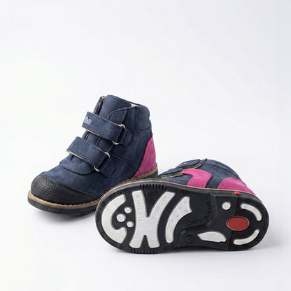 Girls’ orthopedic shoe in navy and pink with Velcro straps, arch support, Thomas heel, and Ortho Shoes branding.
