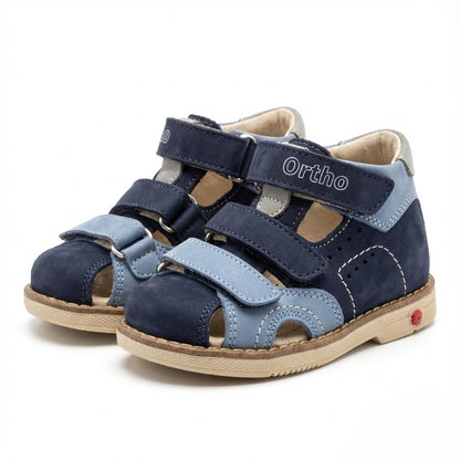 Children’s orthopedic sandals in blue with Velcro straps, arch and ankle support, Thomas heels and Ortho Shoes branding.