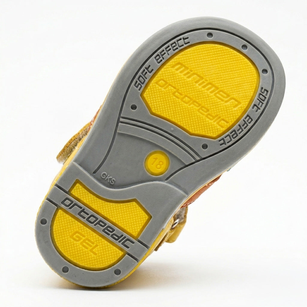 Children’s yellow orthopedic sandal with Velcro strap, brown and turquoise accents, supportive grey sole, featuring arch and ankle support, and Thomas heels by Minimen.