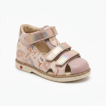 Girls’ orthopedic sandals in pink with Velcro straps, arch and ankle support, Thomas heels and iridescent underwater‑animal print, shown in a retro ice‑cream shop by Ortho Shoes.