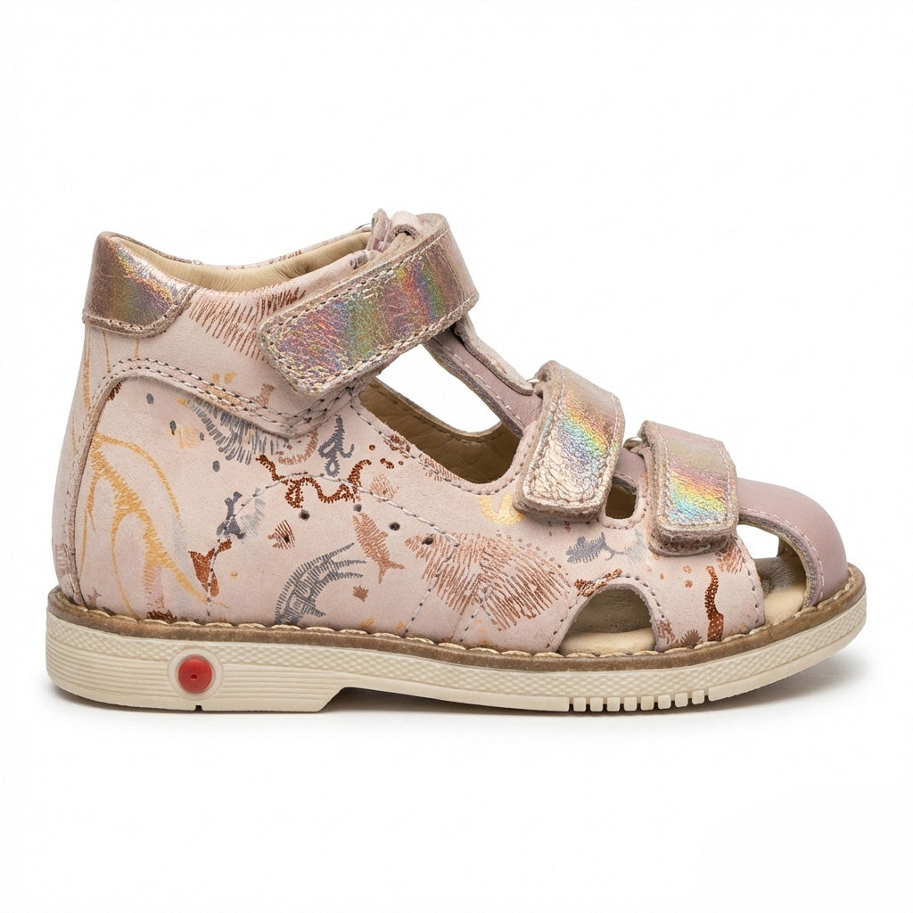 Girls’ orthopedic sandals in pink with Velcro straps, arch and ankle support, Thomas heels and iridescent underwater‑animal print, shown in a retro ice‑cream shop by Ortho Shoes.