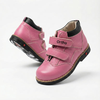 Girls’ orthopedic boots in pink with Velcro closure, arch and ankle support, Thomas heels, and black sole by Ortho Shoes.