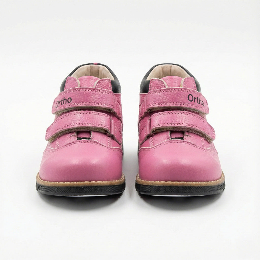 Girls’ orthopedic boots in pink with Velcro closure, arch and ankle support, Thomas heels, and black sole by Ortho Shoes.