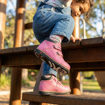 Girls’ orthopedic boots in pink with Velcro closure, arch and ankle support, Thomas heels, and black sole by Ortho Shoes.