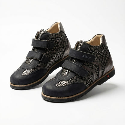 Kids’ orthopedic boots with Velcro straps, metallic pebble design, arch and ankle support, Thomas heels, and Kiddy logo.
