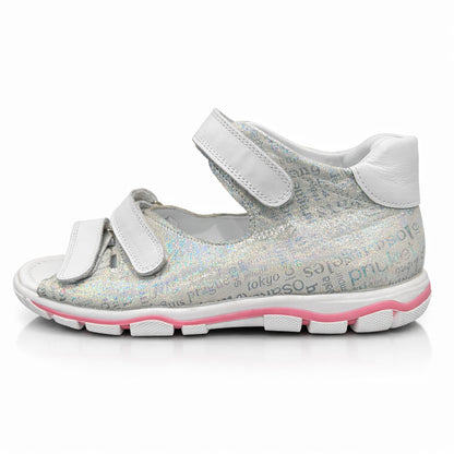 Girls’ orthopedic sandals in silver with white Velcro straps, arch and ankle support, and city-name print by Ortho Shoes.