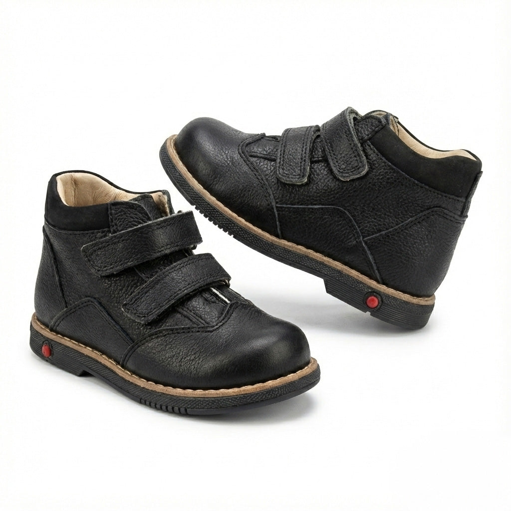 Supportive black orthopedic half-boots for kids with Velcro closure, arch and ankle support, Thomas heels, rugged sole, and dust-resistant design by Ortho Shoes.