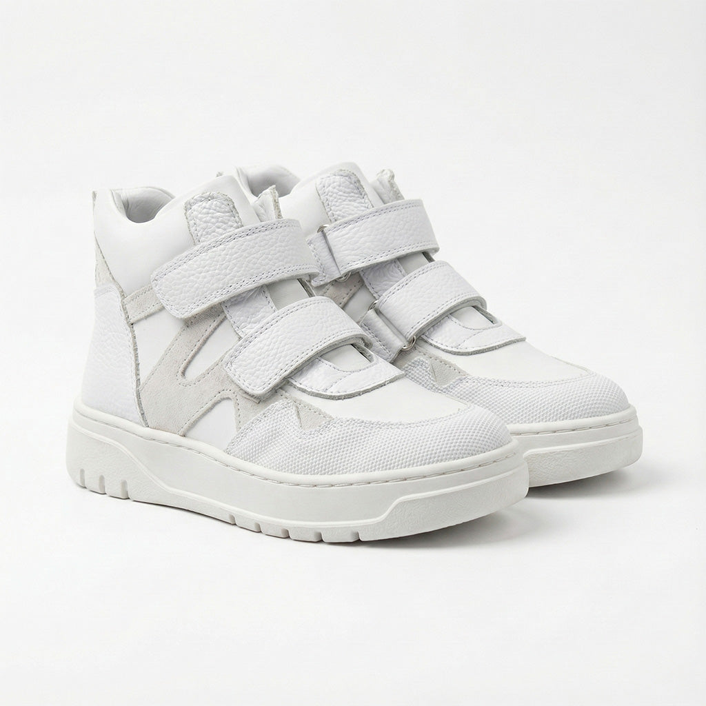 Children’s white orthopedic high-top sneakers with Velcro straps, ankle support, durable sole by Ortho Shoes.